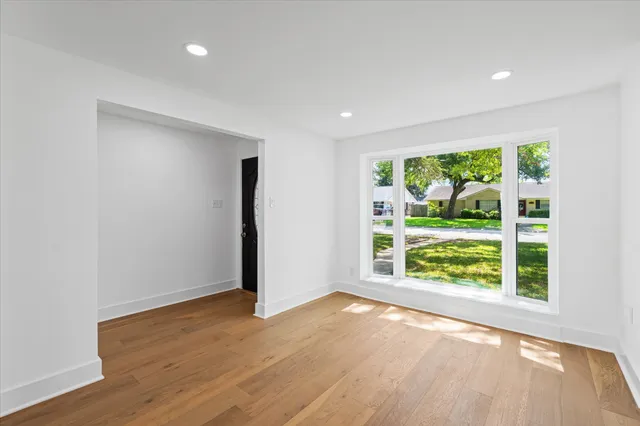 an empty room with wooden floor and outdoor view
