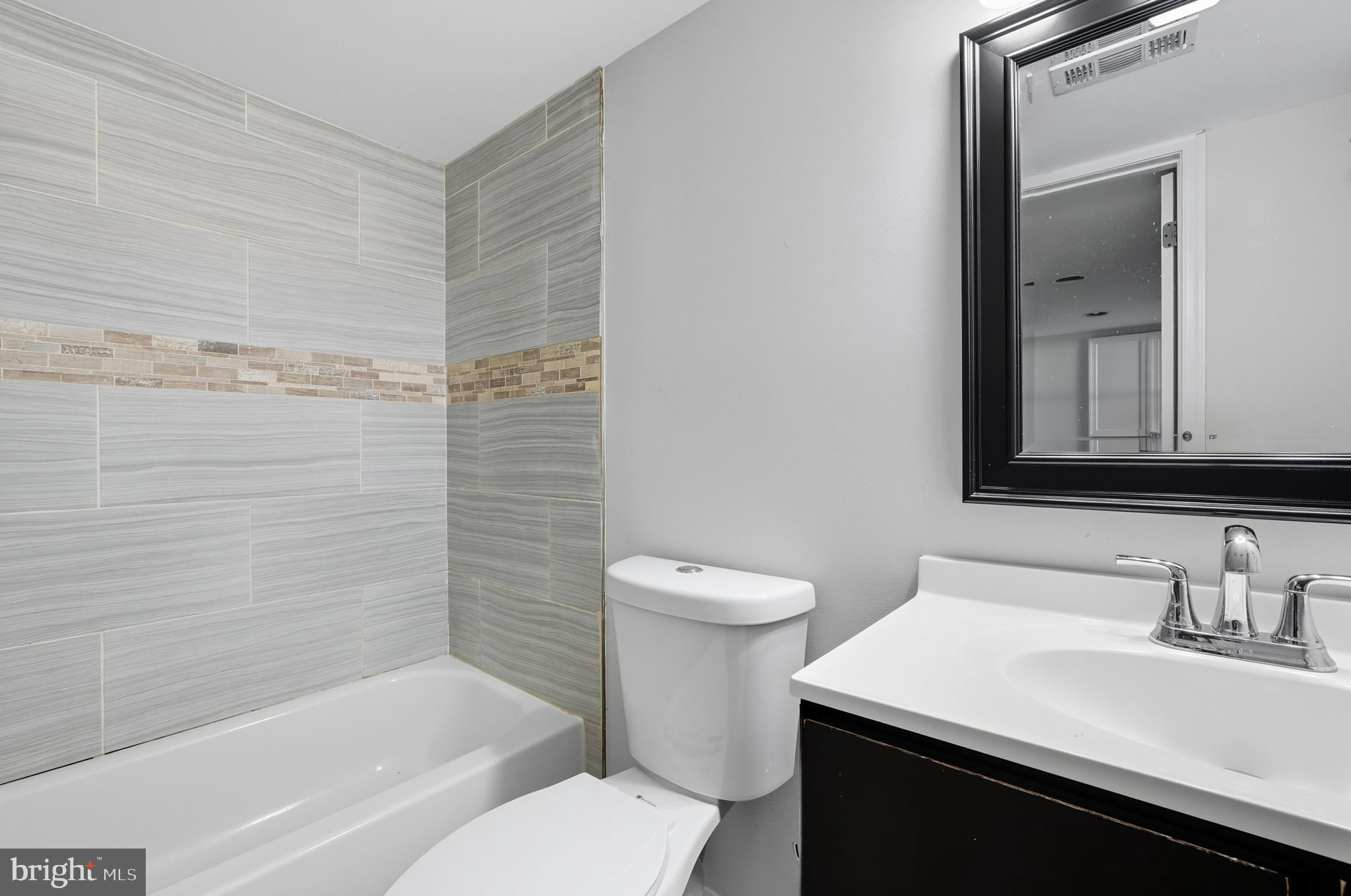 5768 Maplehill Road Baltimore, MD 21239 - Photo 12 of 29 a bathroom with a sink toilet vanity and shower