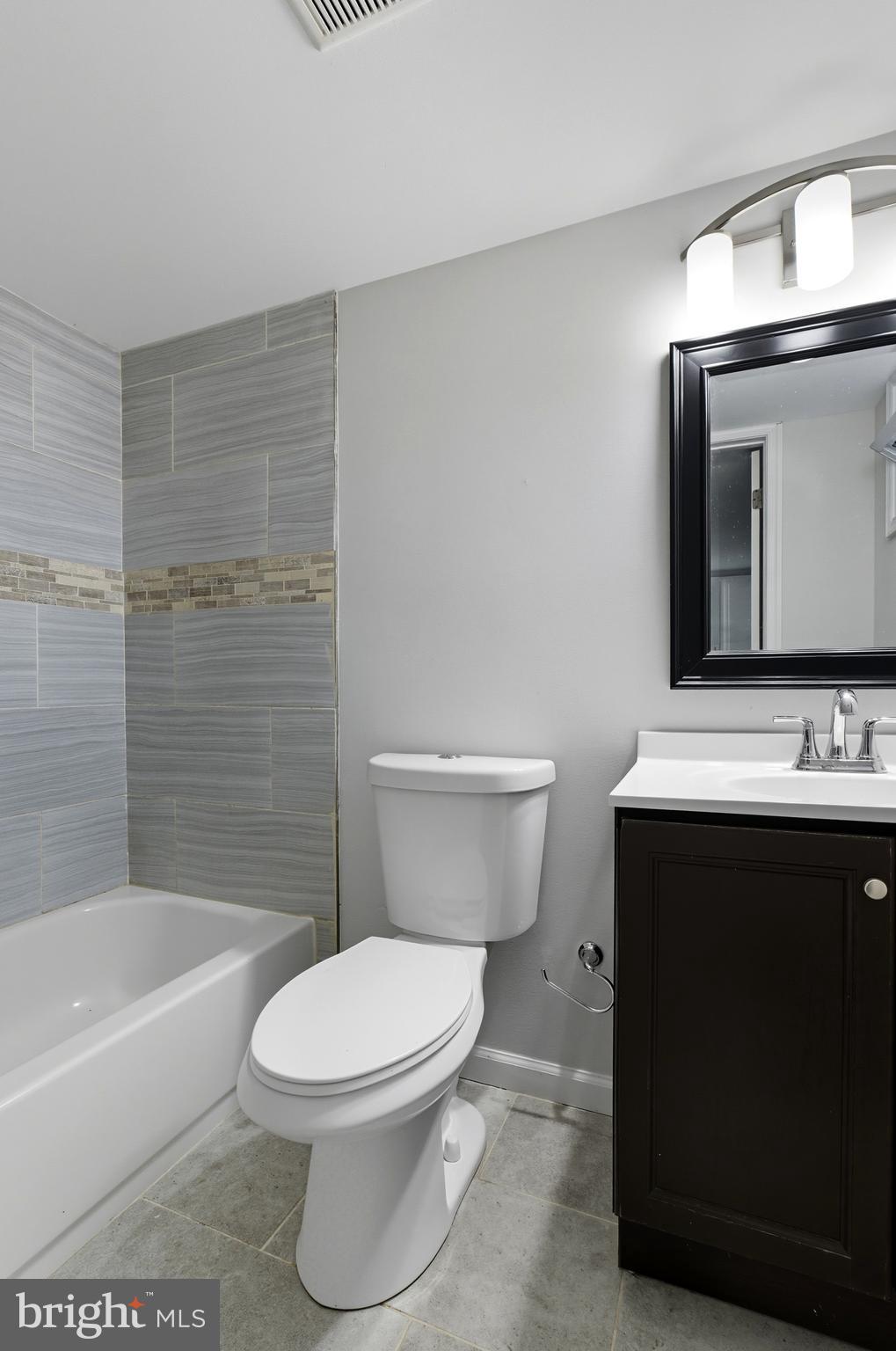 5768 Maplehill Road Baltimore, MD 21239 - Photo 13 of 29 a bathroom with a toilet a sink and bathtub
