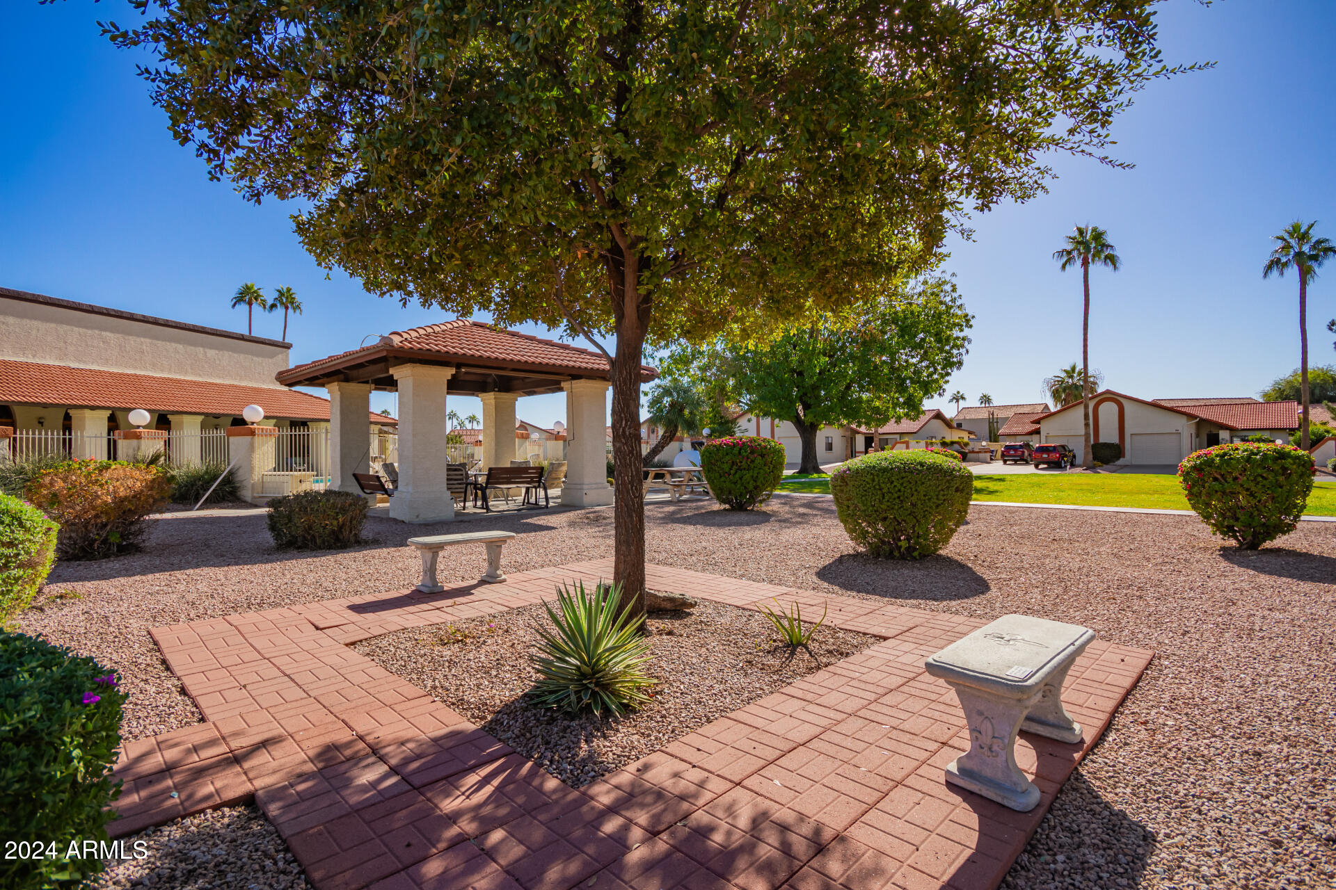 542 South Higley Road, Unit 73 Mesa, AZ 85206 - Photo 24 of 34 a view of a patio with table and chairs potted plants and a large tree
