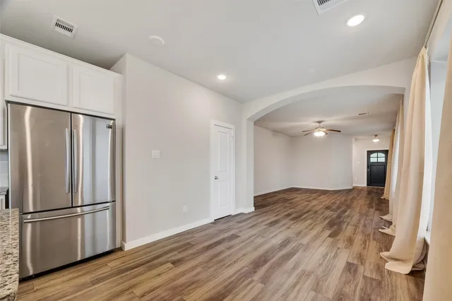 a view of a kitchen with a refrigerator and wooden floor