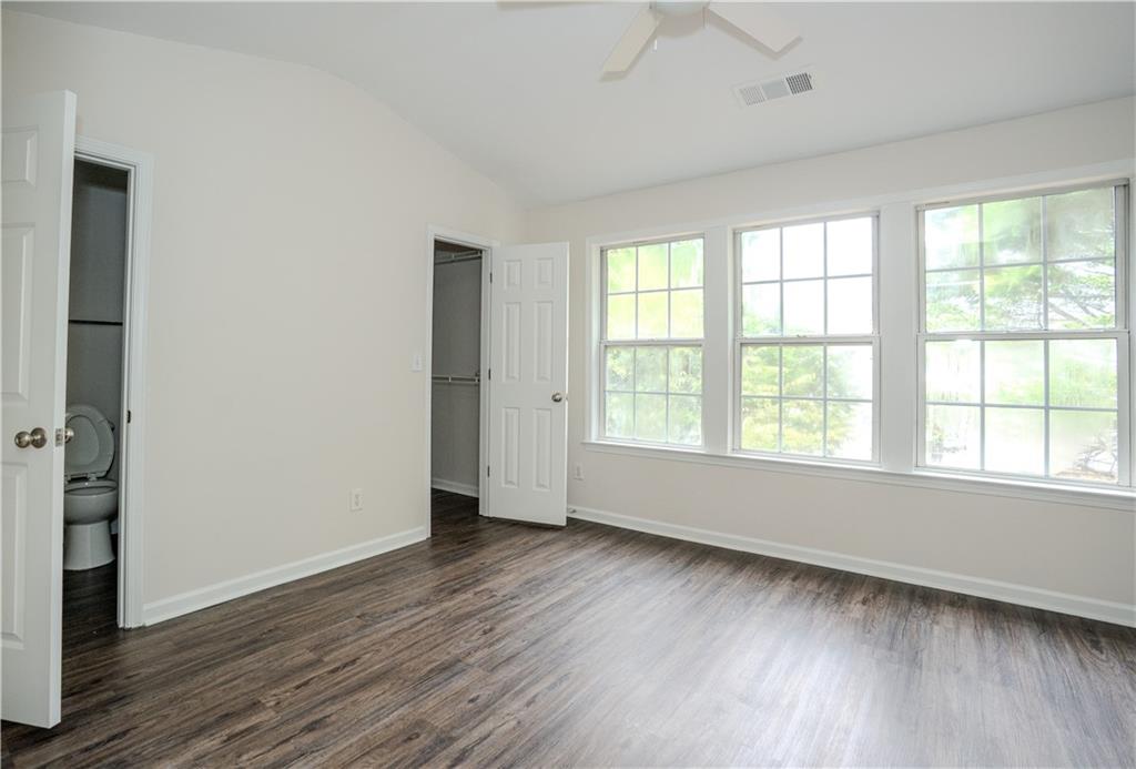 4645 Valais Court, Unit 109 Alpharetta, GA 30022 - Photo 16 of 27 an empty room with wooden floor and windows
