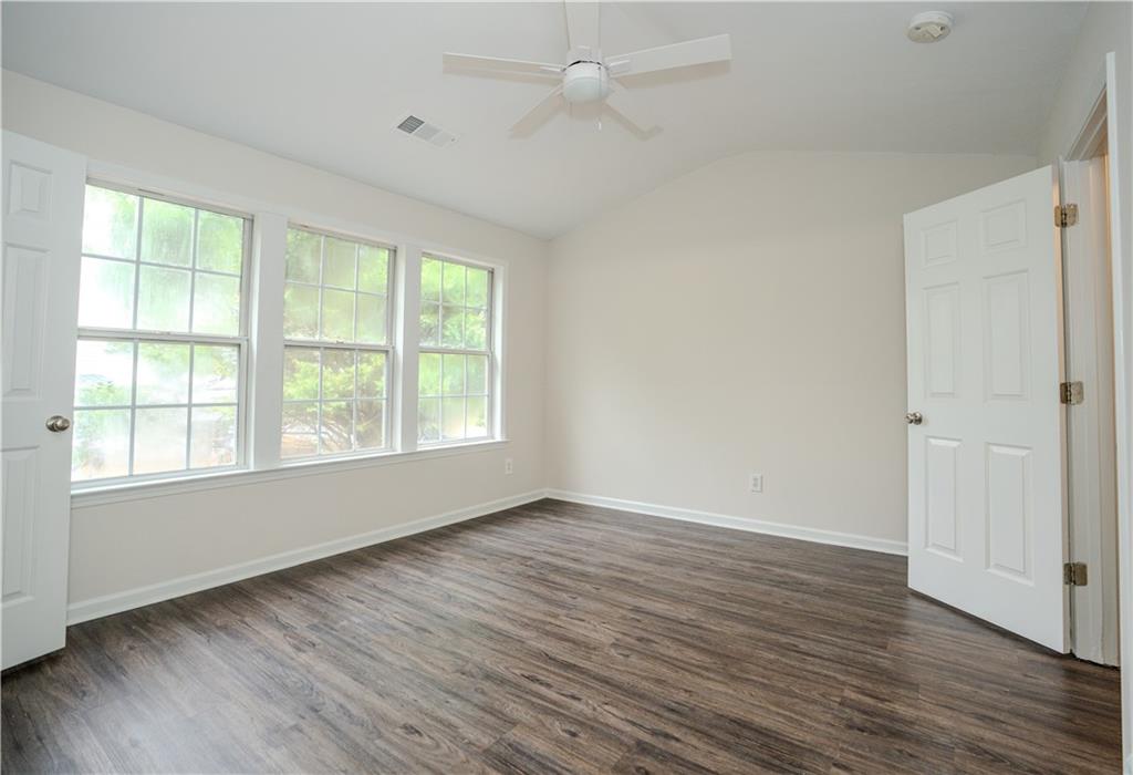 4645 Valais Court, Unit 109 Alpharetta, GA 30022 - Photo 18 of 27 an empty room with wooden floor and windows