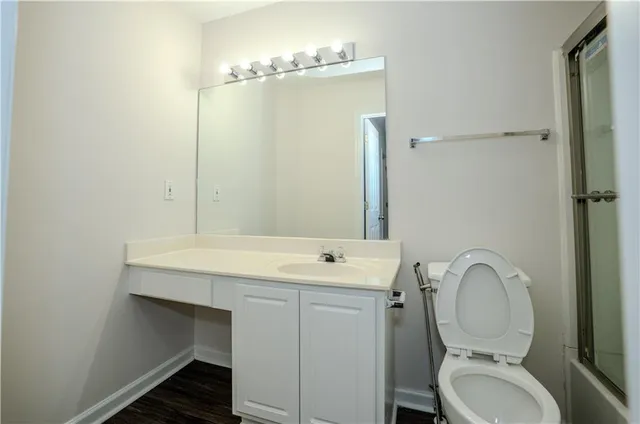 a bathroom with a toilet a sink and mirror
