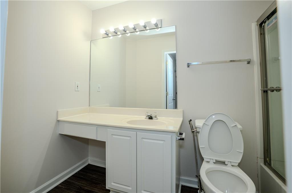 4645 Valais Court, Unit 109 Alpharetta, GA 30022 - Photo 19 of 27 a bathroom with a toilet a sink and mirror