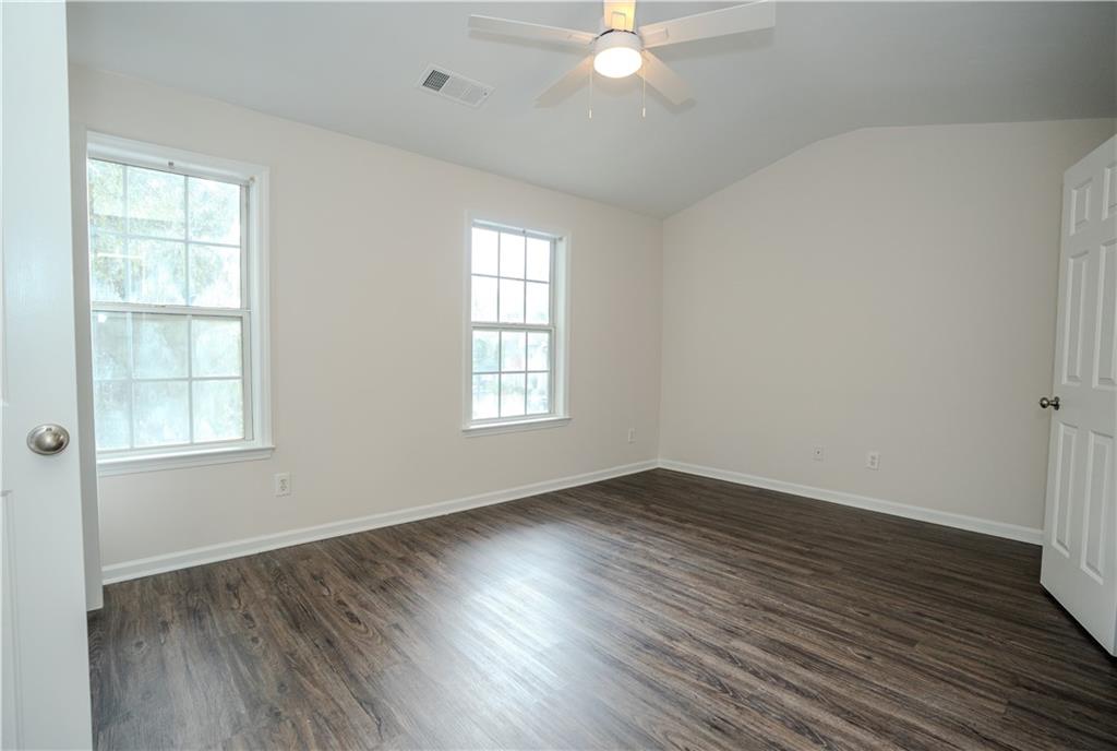 4645 Valais Court, Unit 109 Alpharetta, GA 30022 - Photo 23 of 27 an empty room with wooden floor and windows