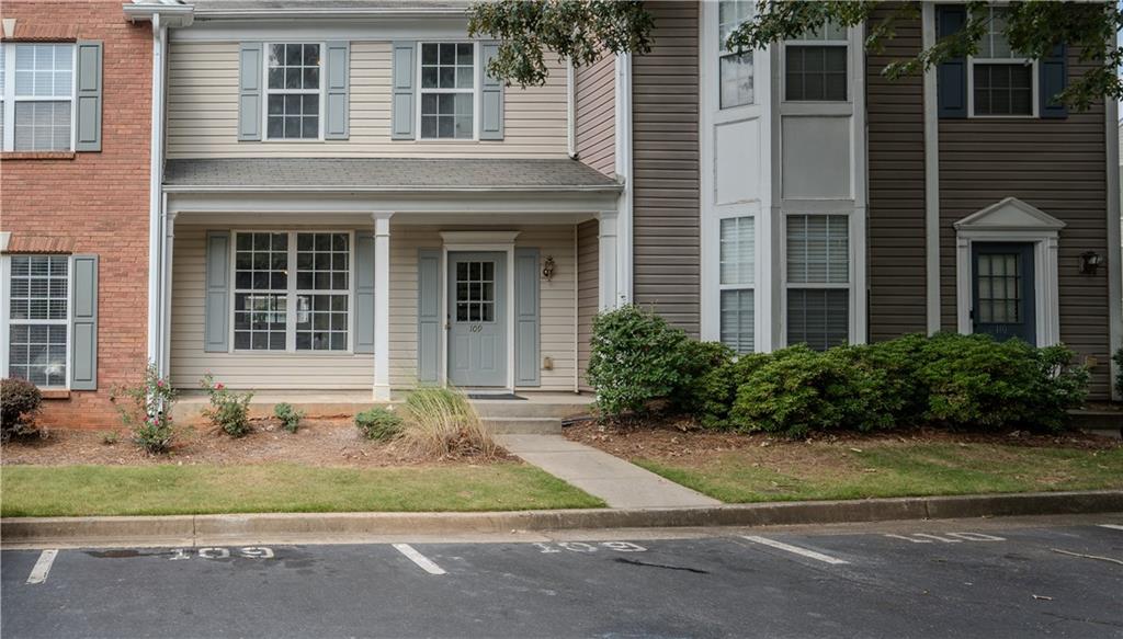 4645 Valais Court, Unit 109 Alpharetta, GA 30022 - Photo 27 of 27 a front view of a house with a yard and potted plants