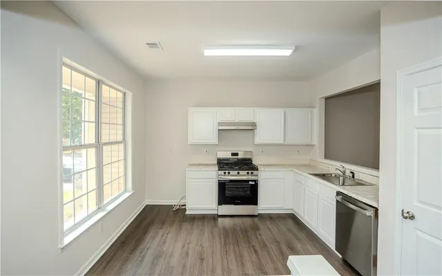 a kitchen with a stove a sink and a refrigerator