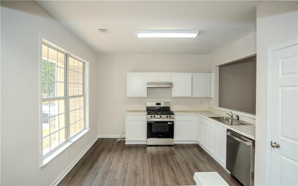 4645 Valais Court, Unit 109 Alpharetta, GA 30022 - Photo 5 of 27 a kitchen with a stove a sink and a refrigerator