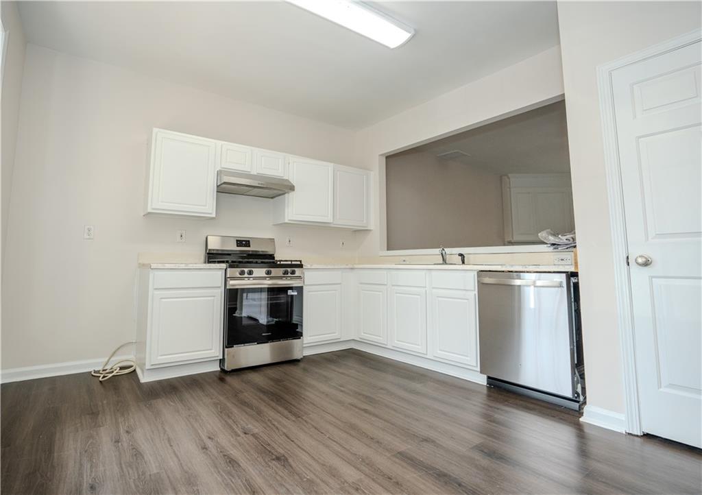 4645 Valais Court, Unit 109 Alpharetta, GA 30022 - Photo 6 of 27 a kitchen with granite countertop a stove and a refrigerator
