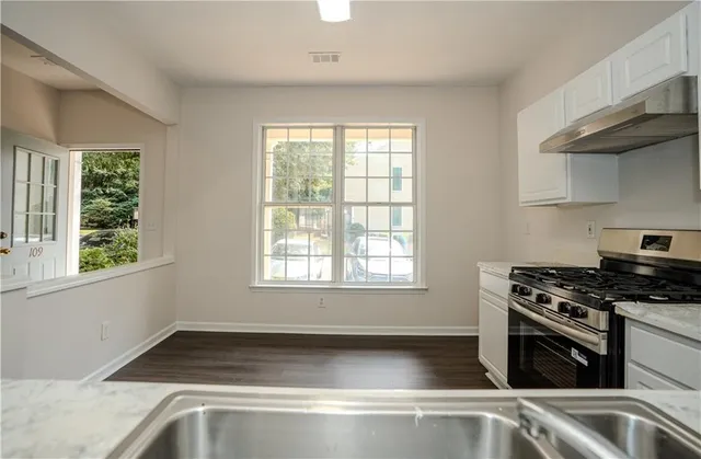 a kitchen with granite countertop a sink and a stove