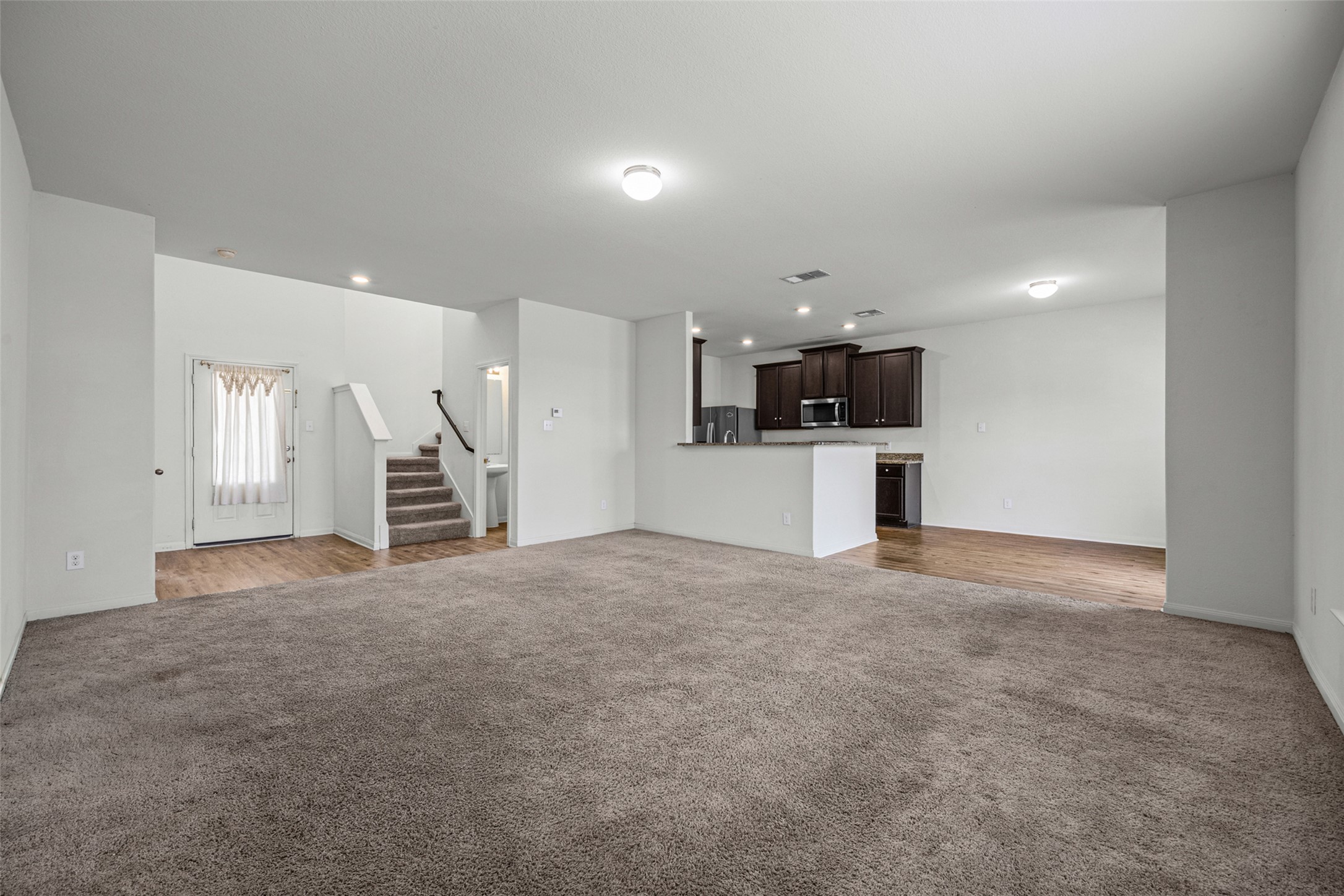19812 Hubert R Humphrey Road Manor, TX 78653 - Photo 28 of 29 An open floorplan seamlessly connects the inviting living room to the well-appointed kitchen and entryway.
