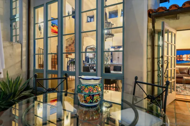 a dining room with furniture and large windows