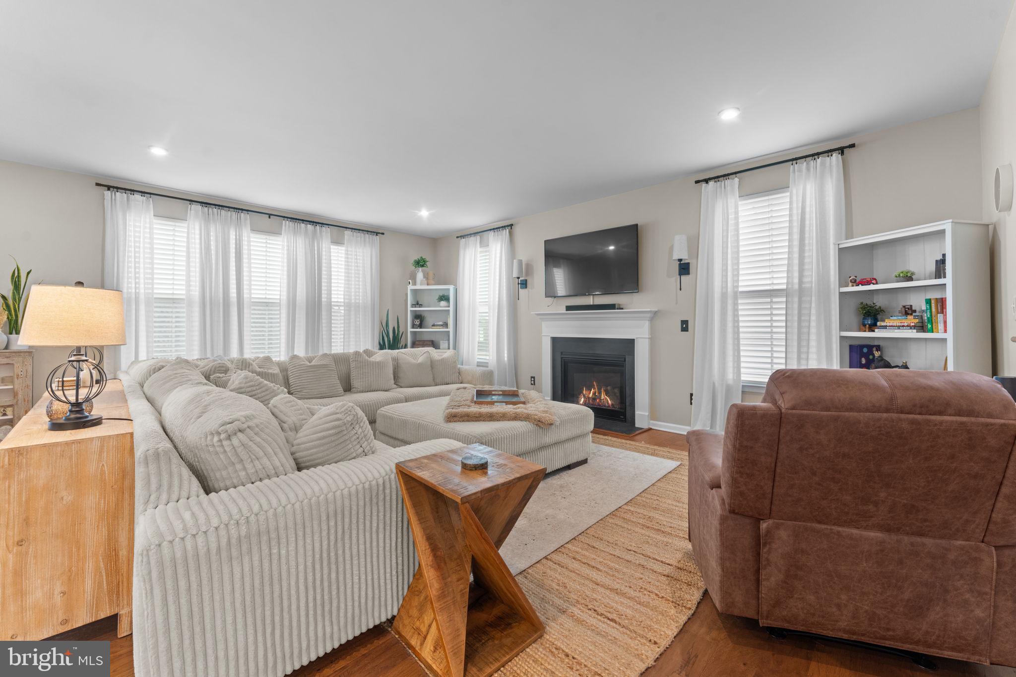 12432 Mays Quarter Road Woodbridge, VA 22192 - Photo 16 of 94 a living room with furniture a flat screen tv and a fireplace
