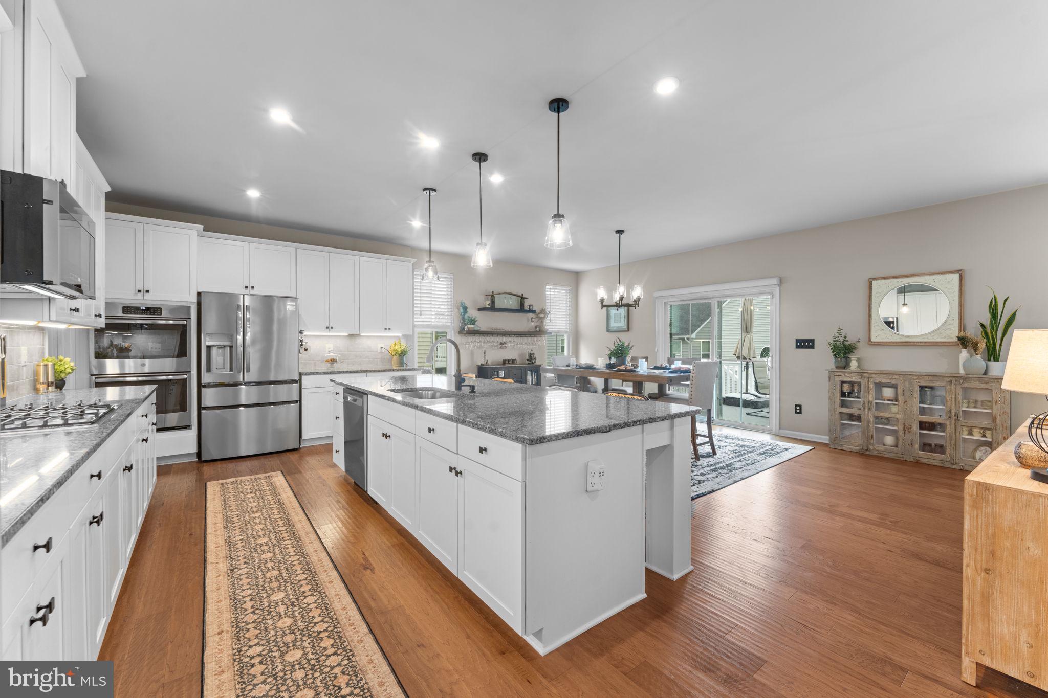 12432 Mays Quarter Road Woodbridge, VA 22192 - Photo 19 of 94 a large kitchen with stainless steel appliances kitchen island granite countertop a large island in the center
