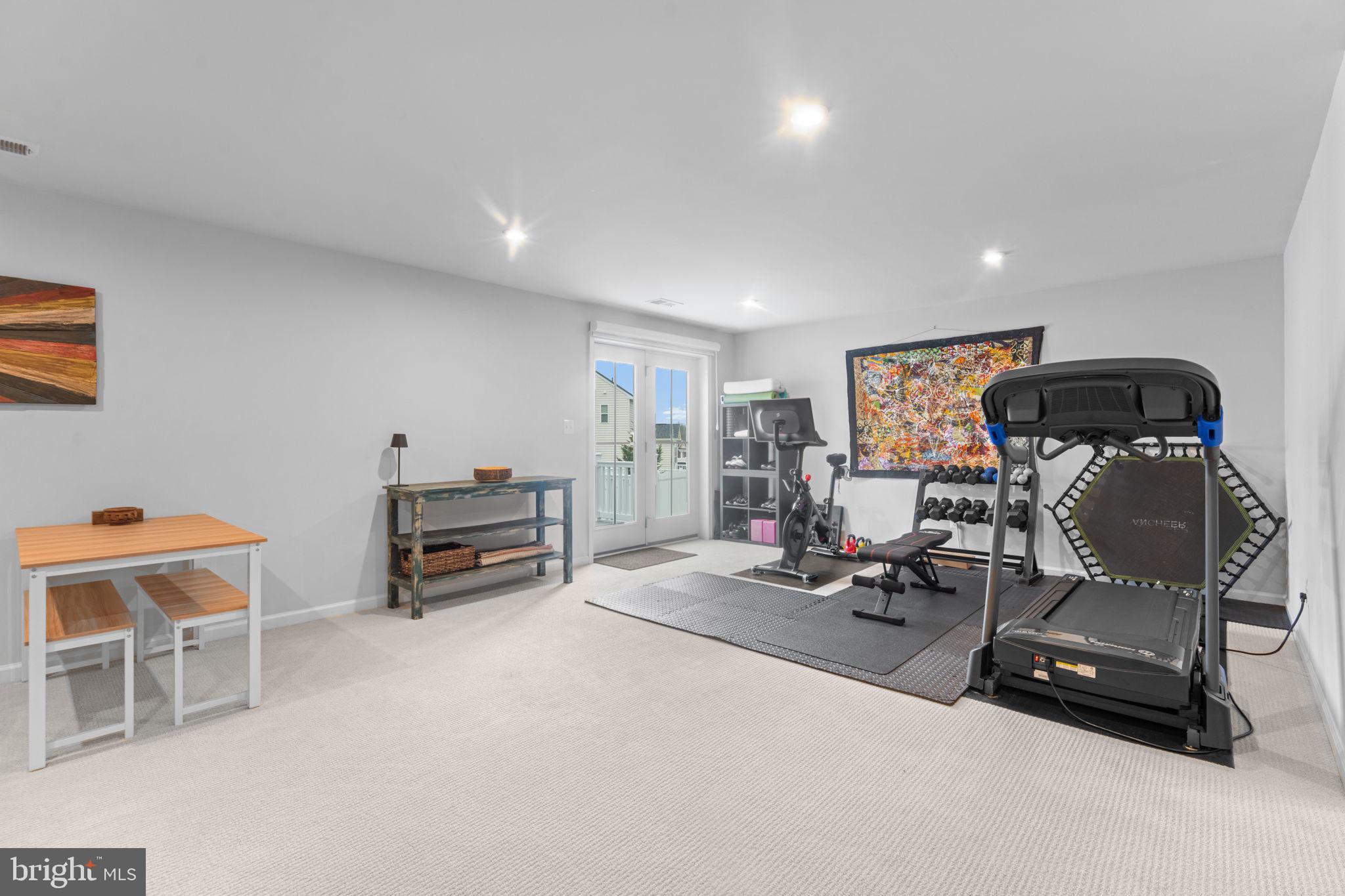 12432 Mays Quarter Road Woodbridge, VA 22192 - Photo 59 of 94 a living room with furniture a flat screen tv and gym equipment