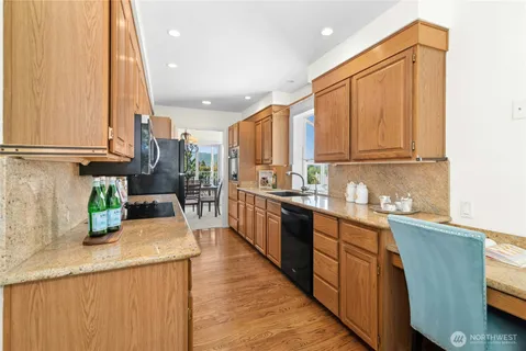 a kitchen with stainless steel appliances granite countertop wooden cabinets a sink and dishwasher a oven with wooden floor