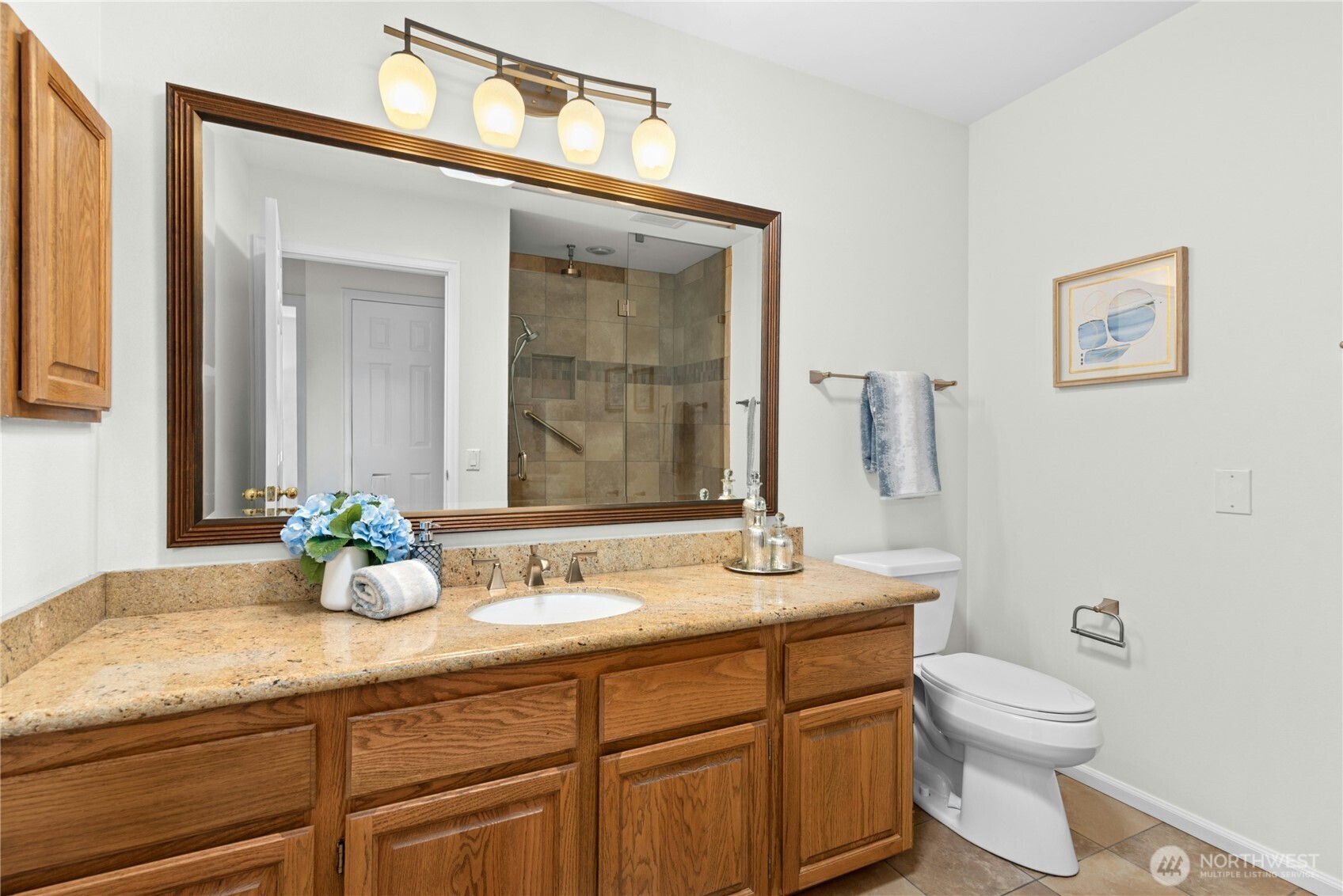 22541 Southeast 42nd Court, Unit 2252 Issaquah, WA 98029 - Photo 17 of 37 a bathroom with a granite countertop sink a toilet and mirror