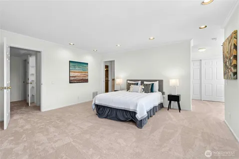 a spacious bedroom with a bed and a painting