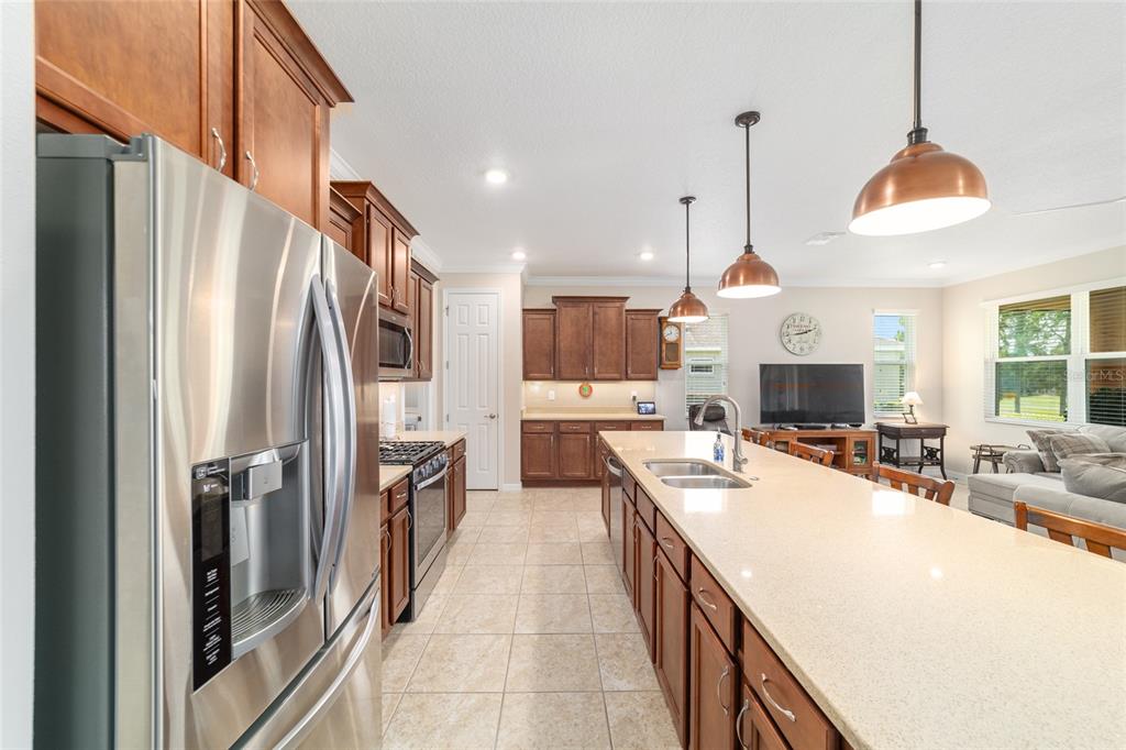 9236 Southwest 91st Ct Road Ocala, FL 34481 - Photo 23 of 48 a kitchen with stainless steel appliances a refrigerator a sink dishwasher a oven and a dining table with wooden floor