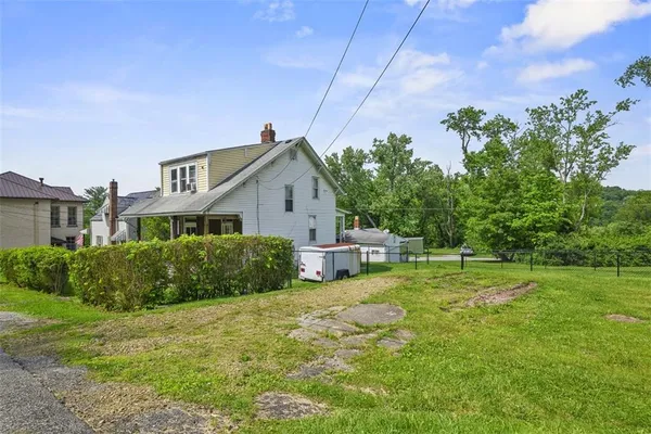 a view of house with a backyard
