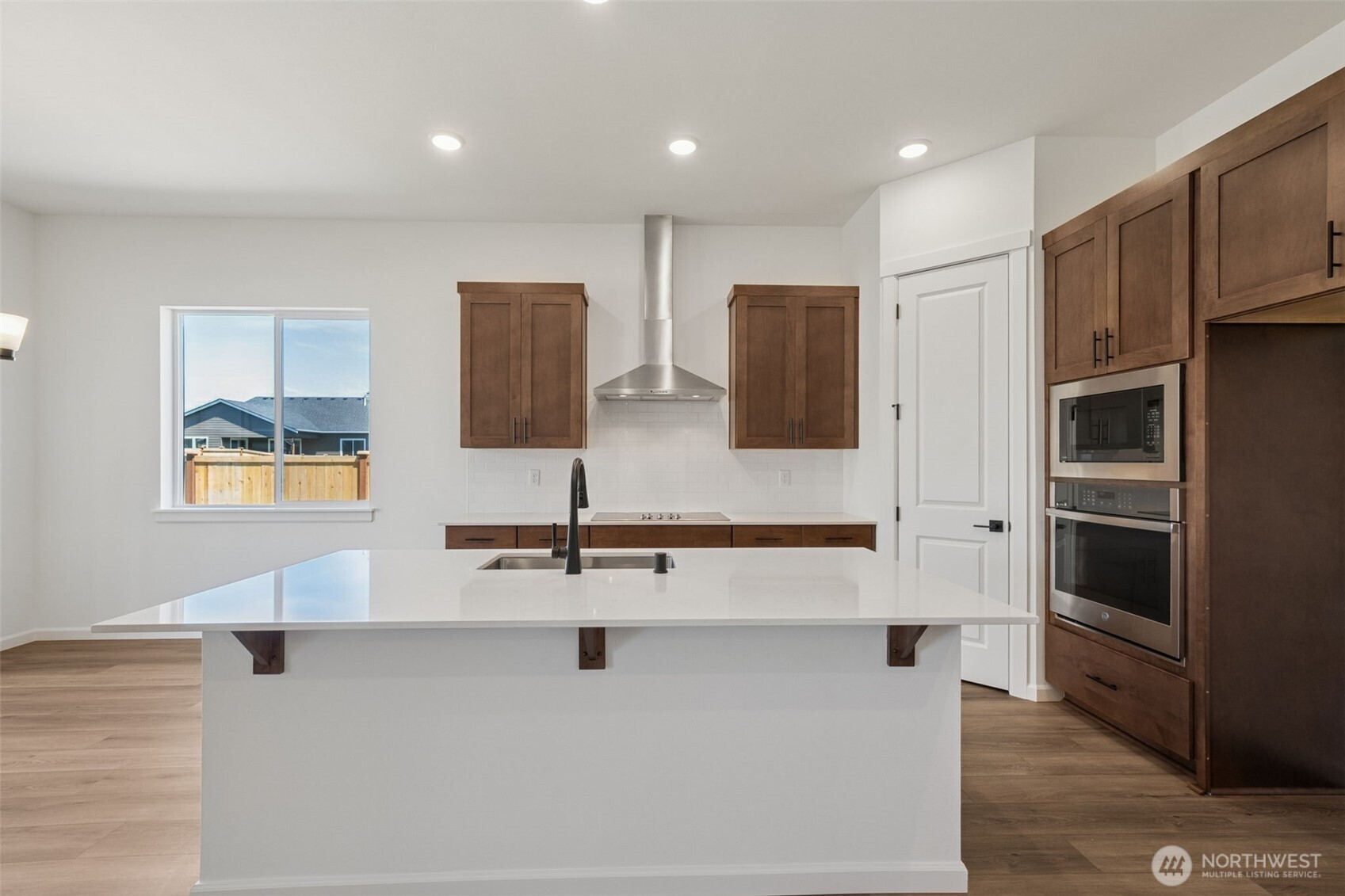 932 Lucas Avenue, Unit 21 Buckley, WA 98321 - Photo 15 of 30 a view of a kitchen with stainless steel appliances wooden floor and windows