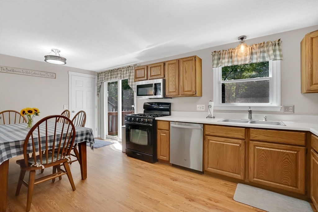 19 Ruthven Street Springfield, MA 01128 - Photo 6 of 19 a kitchen with granite countertop a stove a sink a dining table and chairs
