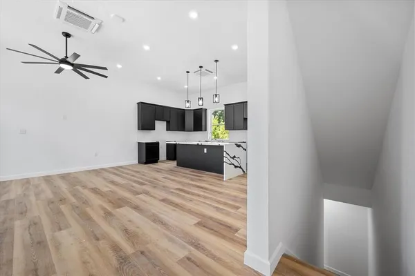 a large room with kitchen view and a chandelier