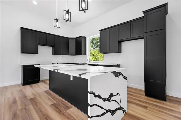 a kitchen with a sink a refrigerator and a stove top oven