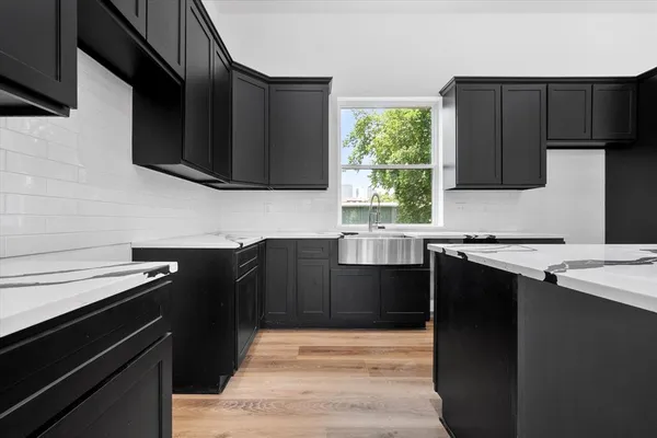 a kitchen with granite countertop a sink cabinets and stainless steel appliances
