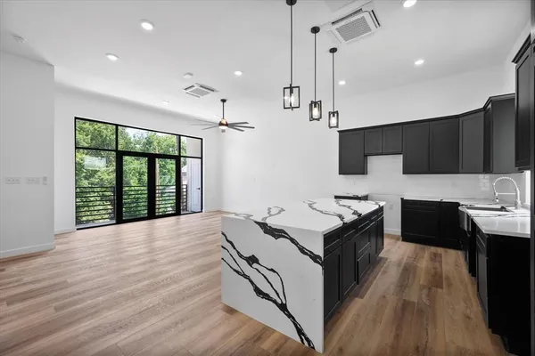 a kitchen with granite countertop a stove a sink a refrigerator and wooden floor