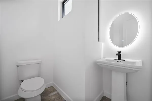 a bathroom with a toilet a sink and mirror