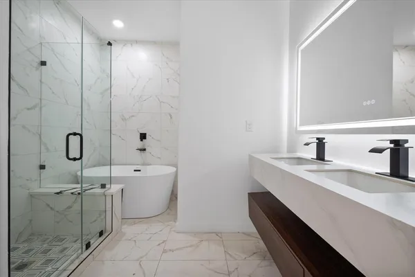 a spacious bathroom with a double vanity sink a mirror and a bathtub