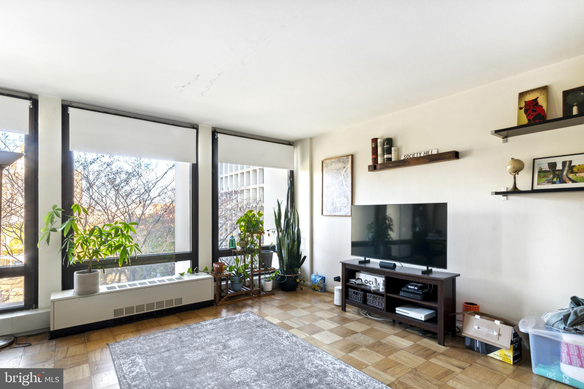 210 Locust Street, Unit 5HW Philadelphia, PA 19106 - Photo 1 of 13 a living room with furniture and a flat screen tv
