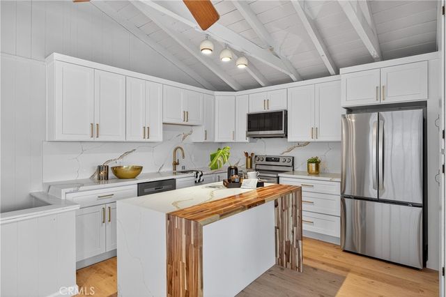 a kitchen with stainless steel appliances granite countertop a refrigerator stove microwave sink and cabinets