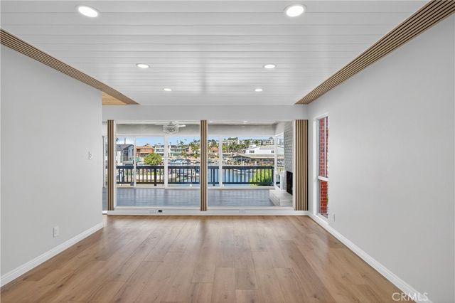 a view of livingroom with an empty room and wooden floor