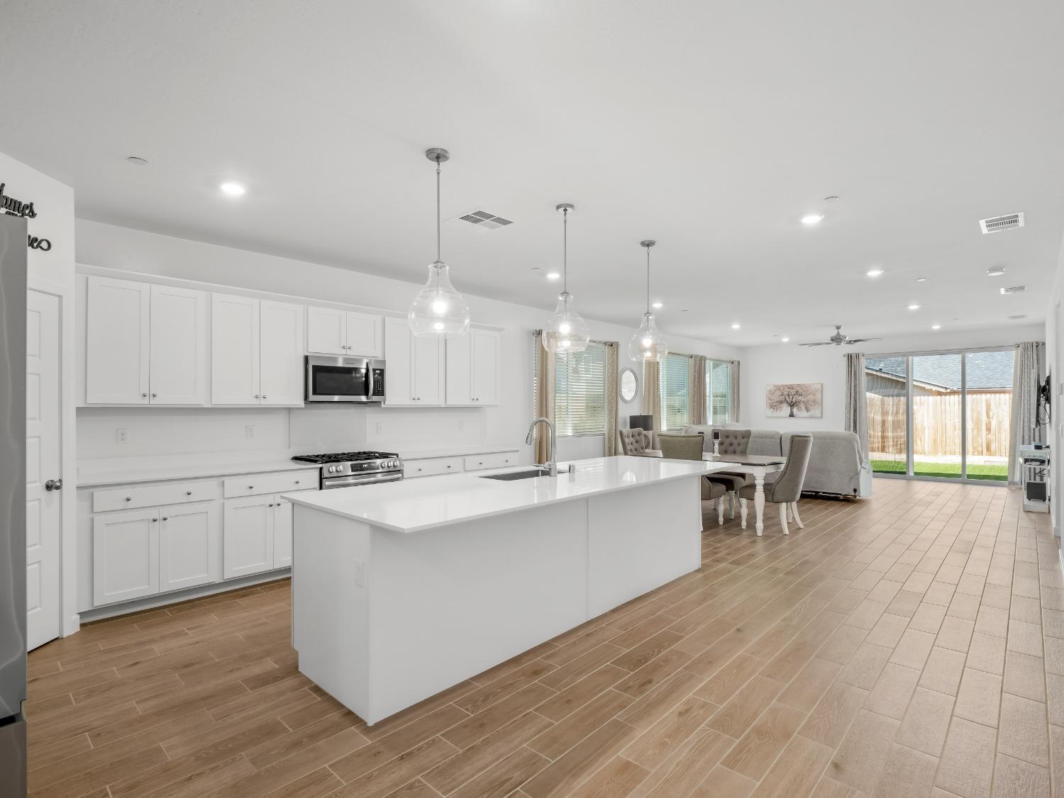 2682 Highland Avenue Clovis, CA 93619 - Photo 3 of 29 a large white kitchen with lots of counter space a sink appliances and living room view