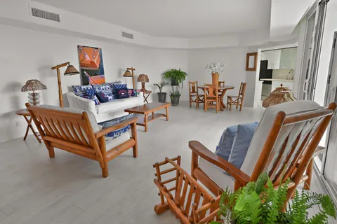 a living room with furniture and a dining table with chairs