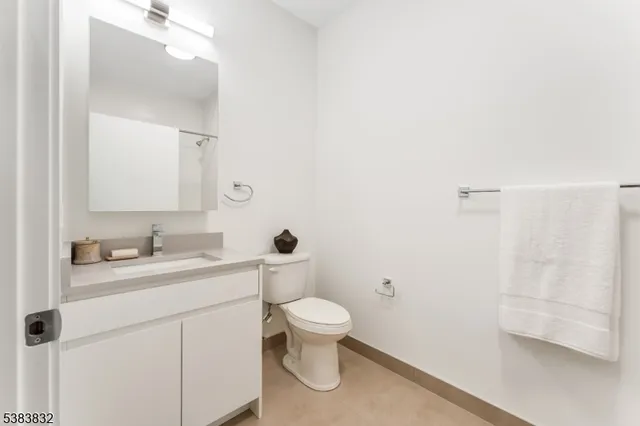 a bathroom with a granite countertop sink a toilet and a mirror