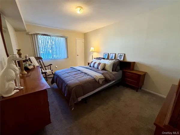 a bedroom with a bed and a dresser next to a window