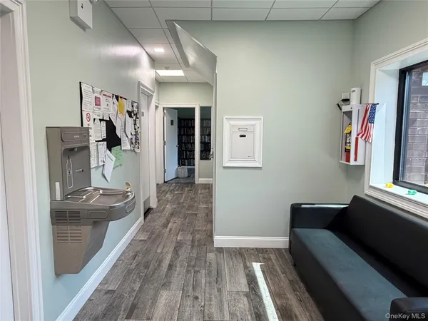 a hallway with a couch and dresser with wooden floor