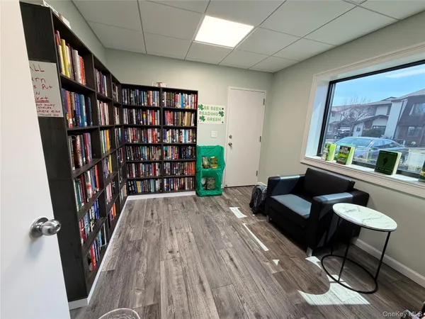 a living room with furniture floor to ceiling window and wooden floor