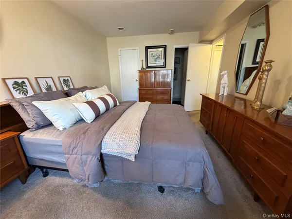 a bedroom with a bed and dresser with mirror