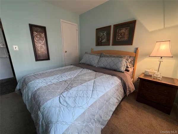 a bedroom with a bed and a lamp on dresser