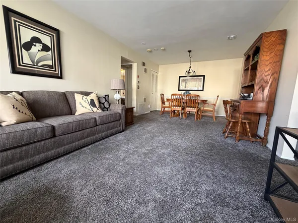 a living room with furniture and a chandelier