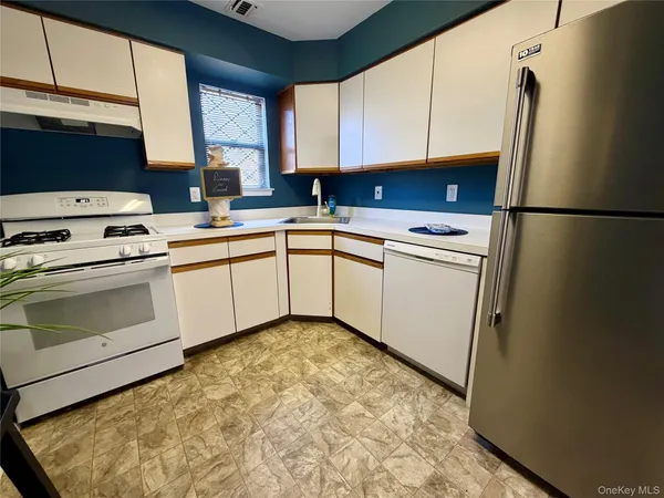 a kitchen with a sink a refrigerator and cabinets