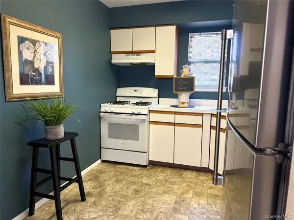 a view of kitchen with cabinets and window