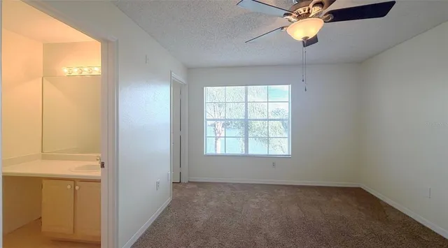 an empty room with a window and a ceiling fan