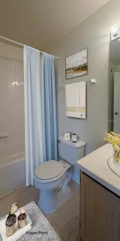 a bathroom with a sink a toilet and shower curtain