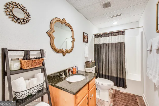 a bathroom with a toilet sink vanity tub and mirror
